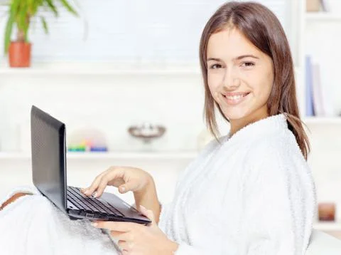 Girl in bathrobe with computer Stock Photos