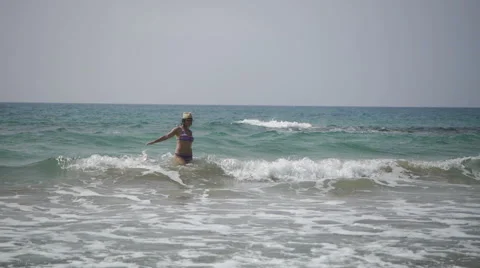 Girl on the beach in a hat in the waves Video stock 63799079