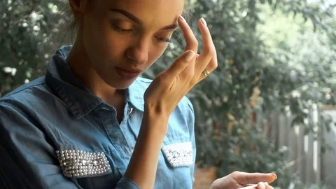 Girl with beautiful eyebrows and denim shirt stands on the street and looking in Stock Footage