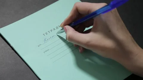 A girl with a beautiful hand writes a script in a clean notebook 库存影片 158909631