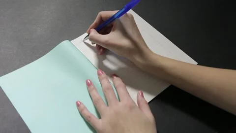 A girl with a beautiful hand writes a script in a clean notebook Stock Footage 158909636