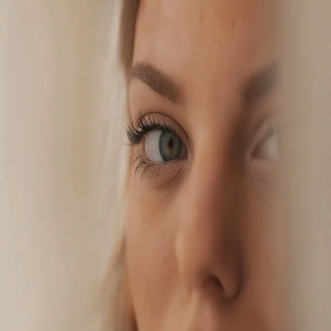 Girl with beautiful make-up looking at the camera through the fabric Stock Footage 69543846