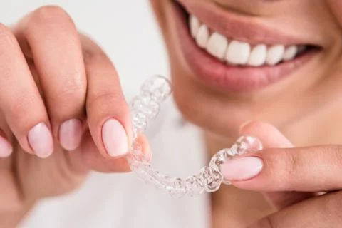 Girl with a beautiful smile holding a transparent mouth guard Stock Photos