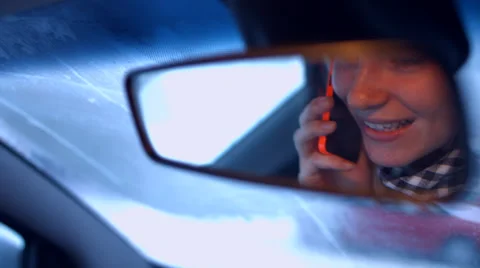 The girl behind the wheel of a car talking on the phone and lipstick. Video stock 59274792