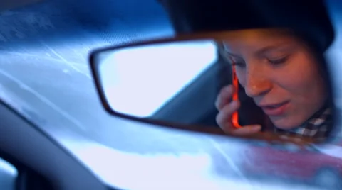 The girl behind the wheel of a car talking on the phone in the rearview mirror Видео 59275194