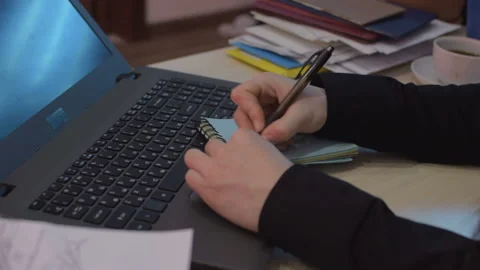 The girl behind the workplace. Record in a notebook important data. Close-up Vídeo Stock 103379145