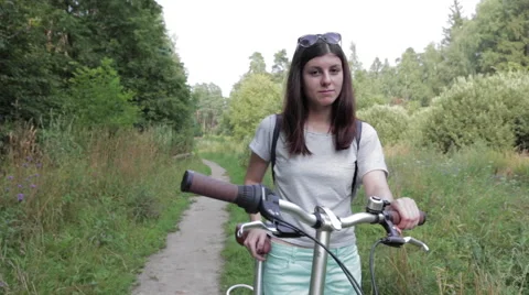 Girl With Bicycle Looking at Camera Stock Footage 67301335