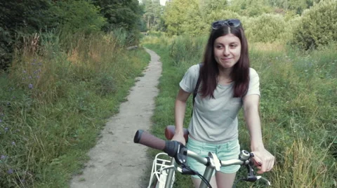 Girl With Bicycle Looking at Camera Stock Footage 67301372