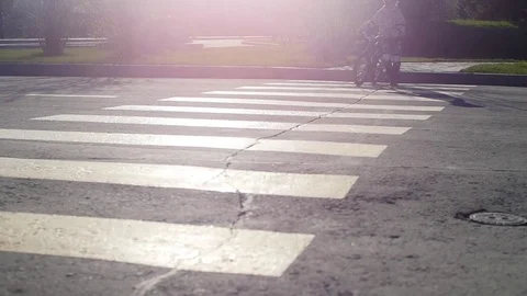 A girl with a bicycle walking on a pedestrian crossing Stock Footage