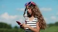 Girl in big glasses in the shape of hearts makes selfie on his smartphone HD Footage