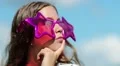 Girl in big pink glasses in the shape of stars looks around and thinks HD Footage