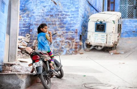 Girl on the bike in Blue city Stock Photos