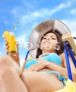 Girl in bikini drinking orange juice. Stock Photos