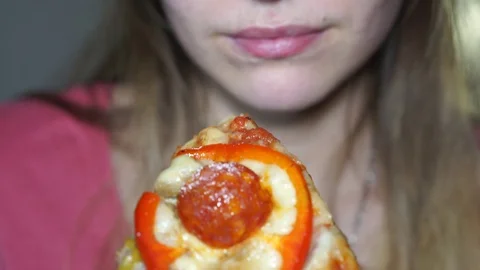 Girl bites a slice of pizza Stock Footage 105199301