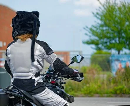 Girl in black and white suit on motorcycle with plush helmet cover Photos