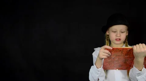 Girl on a black background in white dress reading a book Stock Footage 59447195