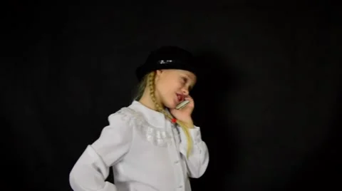 Girl on a black background in a white dress talking on the white smartphone Stock Footage 59447325