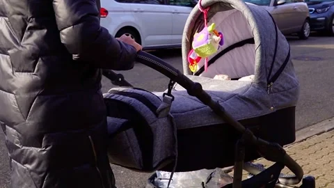 A girl in a black jacket and a gray hat is pushing Stock Footage 299023045