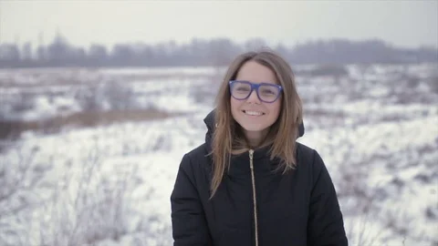 The girl in a black jacket on a background of a winter field Stock-Footage 72311769
