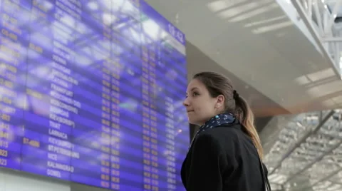 Girl in a black jacket is looking at the schedule at the airport. Stock Footage 64670882