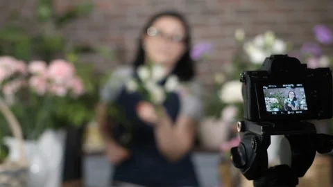 Girl blogger  record tutorial for her online gardening blog about flowers. 動画素材 123684705