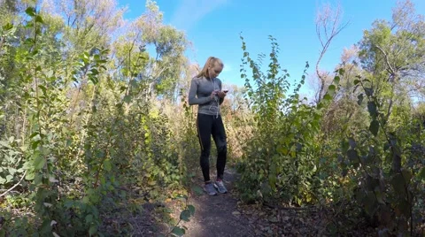 The girl-blonde while jogging in the park stopped play audio player. Video stock 56313845