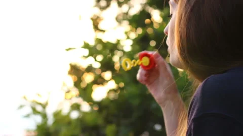 Girl blowing bubbles Vídeo Stock 64990314