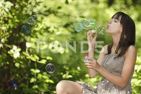 Girl blowing bubbles Stock Photos