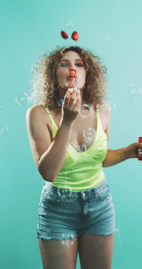 Girl blowing bubbles, while covered in confetti. Stock Footage 204971328