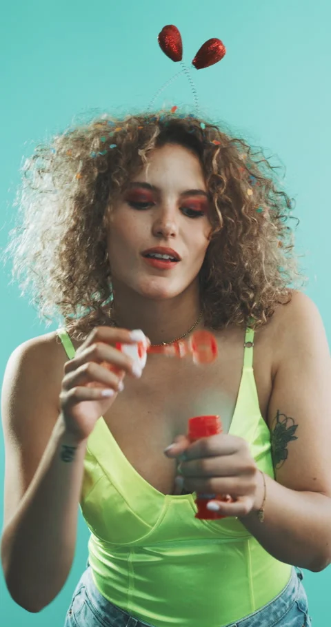 Girl blowing bubbles, while covered in confetti. Stock Footage 204971338