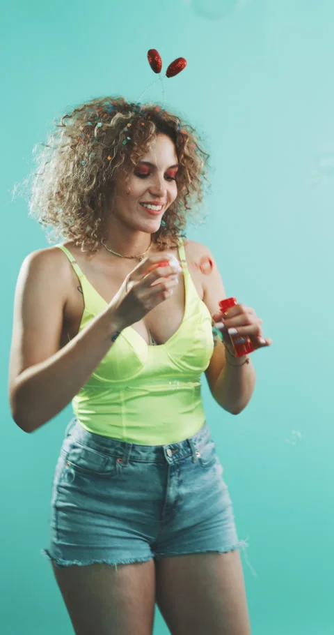 Girl blowing bubbles, while covered in confetti. Stock Footage 204971381