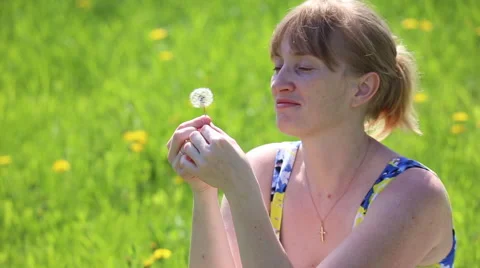 Girl blowing on a dandelion Stock Footage 62935213