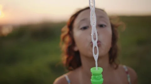 Girl blowing soap bubbles Stock Footage 77563302
