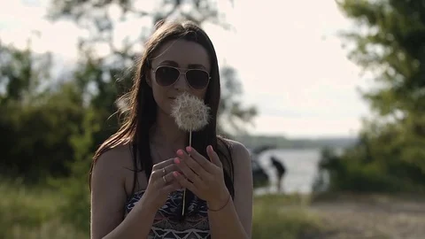 The girl blows away the dandelion Stock Footage