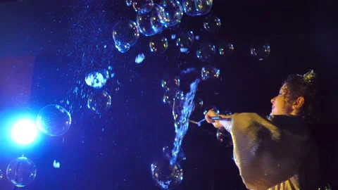 Girl blows soap bubbles.Soap bubbles take off and burst on a black background Stock Footage 220076007