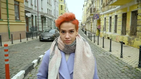 Girl in a blue coat posing at the camera, walking around the city Stock Footage 145153156