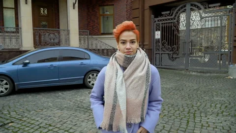 Girl in a blue coat posing at the camera, walking around the city Stock Footage 145345282