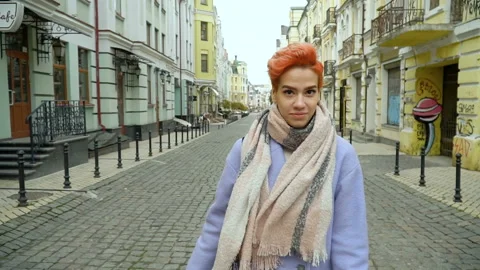 Girl in a blue coat posing at the camera, walking around the city Stock Footage 145345695