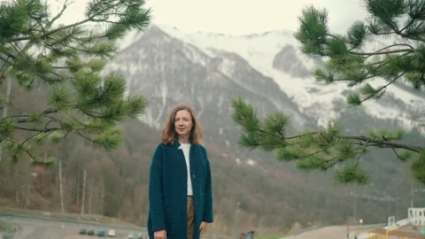 Girl in blue coat posing on camera in mountain in Roza Khutor Stock Footage 158696946