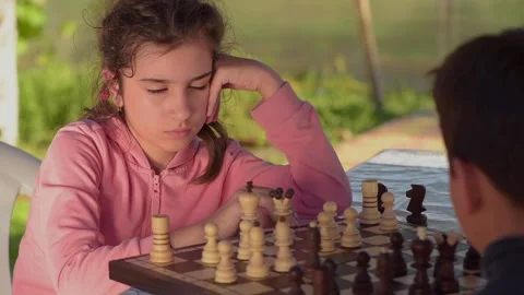 A girl with a boy playing chess Stock Footage 131126897
