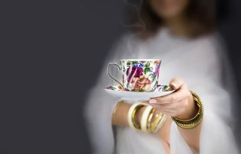 Girl  with bracelets  giving a colorful cup Stock Photos
