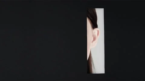 Girl with a bright make-up appears in a rectangular vertical hole Stock Footage 86383151