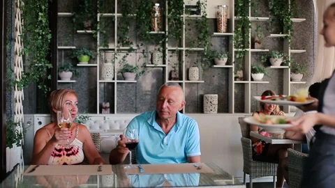 The girl brings food adult couple. Stock Footage