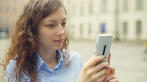 Girl browsing internet on smartphone while sitting on the square Stock-Footage 67395713