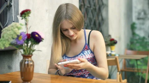 Girl browsing internet on tablet and smiling to the camera in the outdoor cafe Stock-Footage 67756953