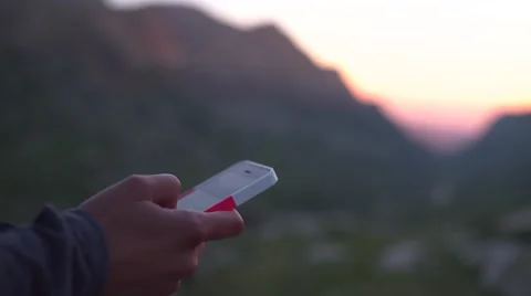 Girl Browsing on iPhone at Mountain Sunset 4K Video stock 65291061