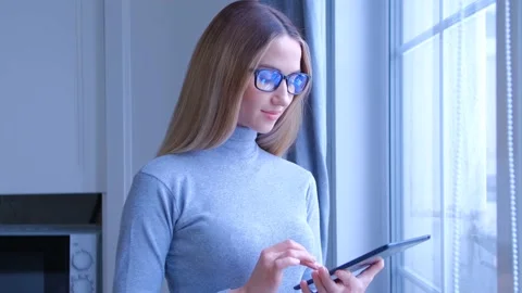 Girl browsing tablet pc gadget with cheerful smile in 4k video clip Stock-Footage 208767607