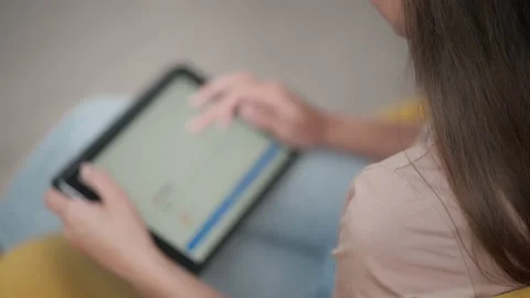 Girl browsing web and looking through photos on digital tablet Stock Footage 224529327