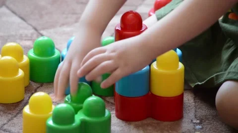 A girl is building a tower from a cylindrical constructor. Close-up. Stock Footage 132214324