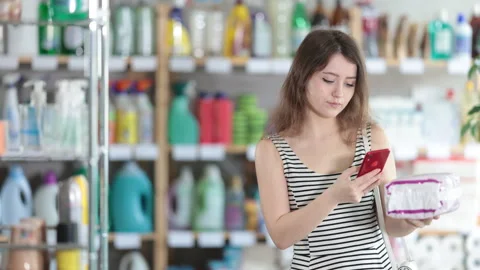 Girl buyer scans qr code on female pads label Stock Footage 308956323